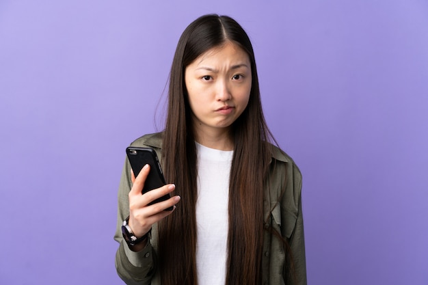 Premium Photo | Young chinese woman using mobile phone over isolated ...