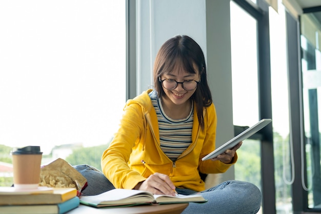Young collage student using computer and mobile device studying online. Premium Photo