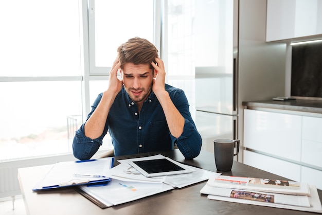 Premium Photo | Young confused man analyzing finances while holding ...