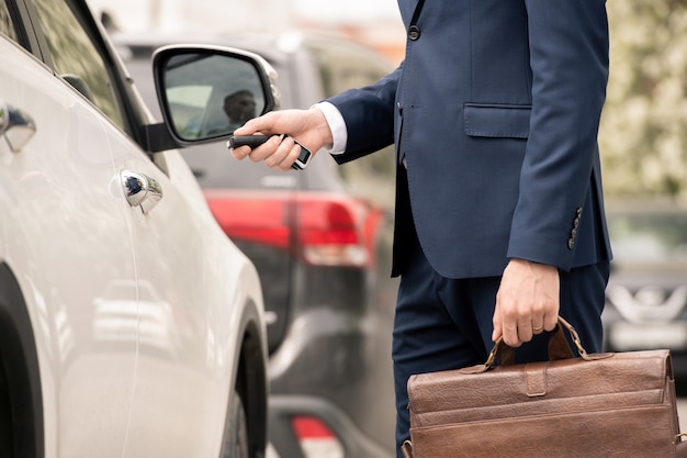 Premium Photo | Young contemporary businessman in suit standing by his ...