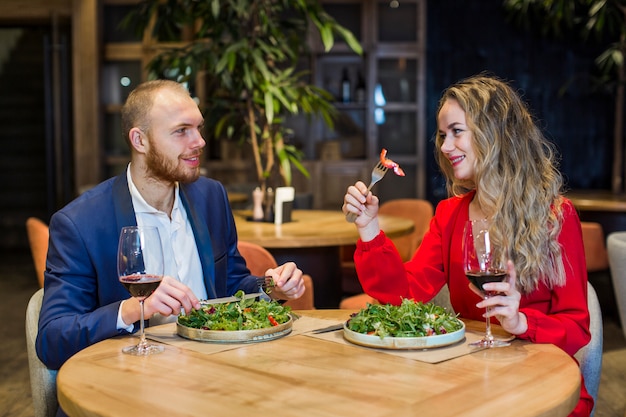 Free Photo | Young couple eating salad in restaurant