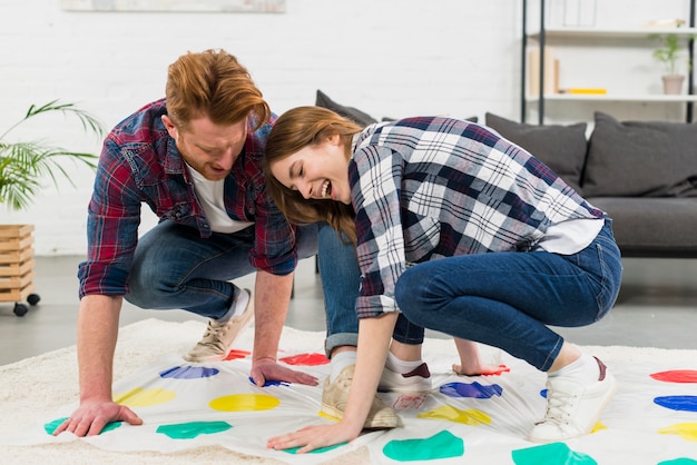 Free Photo | Young couple enjoying the color dot game on carpet at home