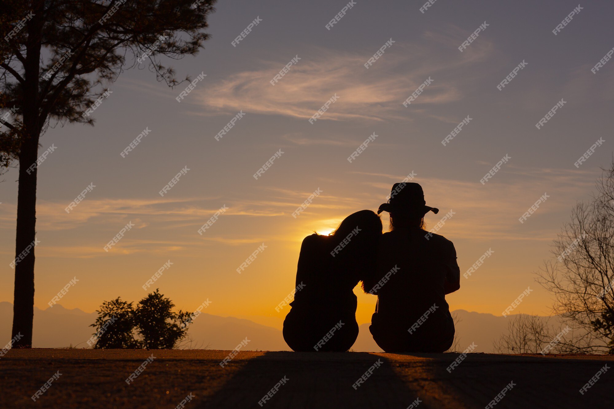 Free Photo | Young couple enjoying the sunset in the mountain