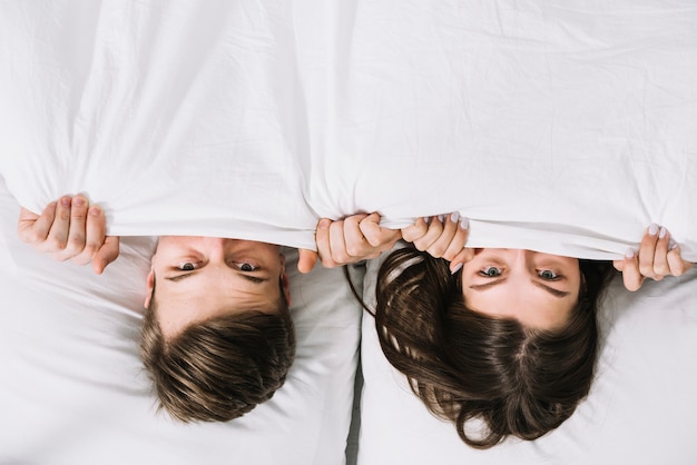 Young Couple Hiding Under Blanket Free Photo