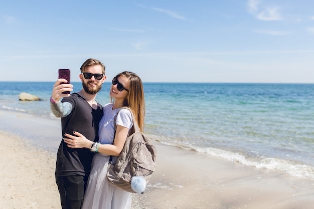 若いカップルは海の近くのselfie写真を撮っています 無料の写真