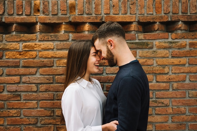 Young Couple Kissing In Front Of Wall Free Photo