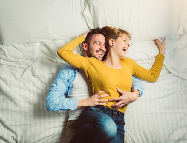 Premium Photo Young Couple Lying In Bed Having Fun Laughing W