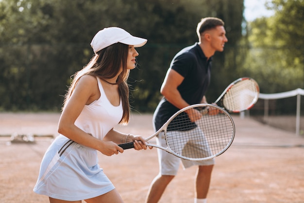 Free Photo | Young couple playing tennis at the court