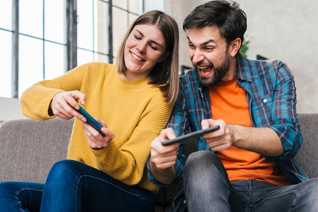 Young couple playing the video game on mobile phone Premium Photo
