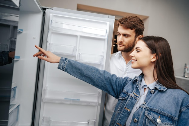 Young couple selecting new refrigerator in household appliance store Free Photo