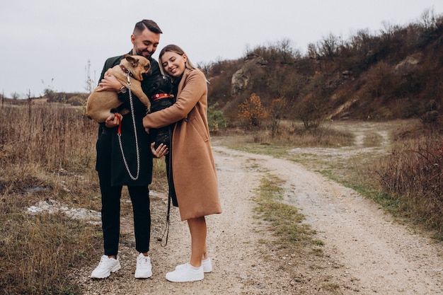 Young Couple Walking Their French Bulldogs In Park Photo Free Download