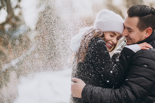 Free Photo | Young couple in winter under the snow falling from the tree