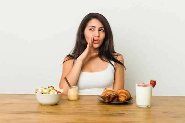 Premium Photo | Young curvy woman taking a breakfast is saying a secret