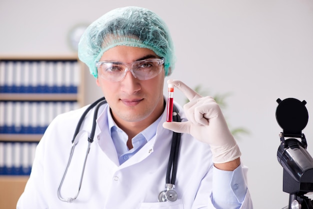 Young doctor working in the lab with microscope Premium Photo