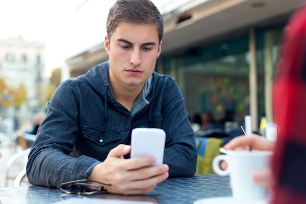 Young entrepreneur  using his mobile  phone at coffee shop 