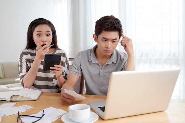 Young family doing family accounting routine stressed by the amount of expenses Free Photo