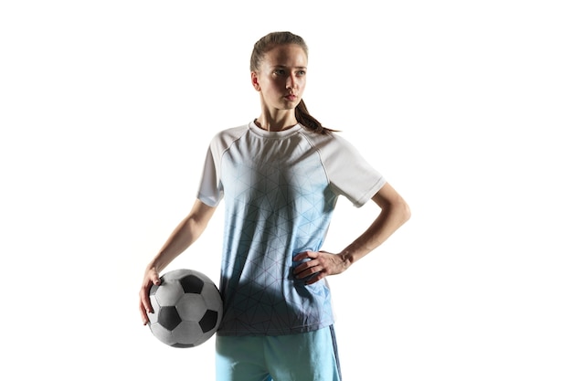 スポーツウェアとブーツで長い髪の若い女性のサッカー選手またはサッカー選手は 白い背景で隔離のボールで立っています 健康的なライフスタイル プロスポーツ 趣味の概念 無料の写真