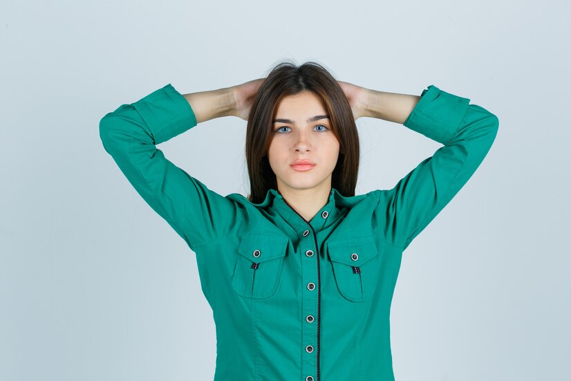 Free Photo | Young female holding hands behind head in green shirt and ...