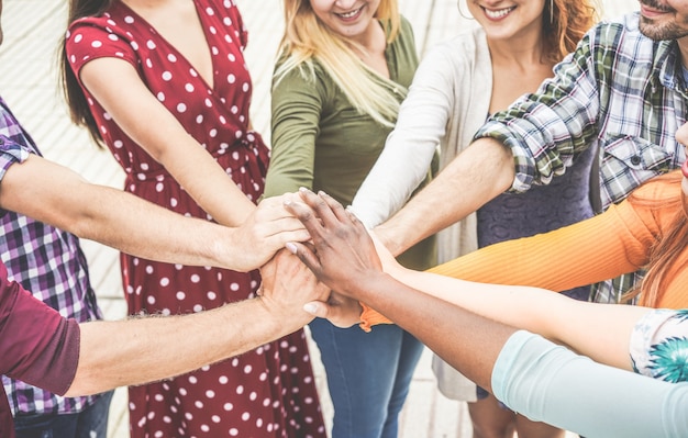 Young friends stacking hands together Premium Photo