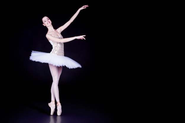 Premium Photo | Young girl ballerina with tutu solo dancing and doing stand toes dark black scene with reflecting floor