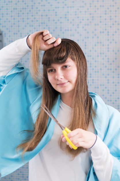 Premium Photo | Young girl cuts her hair herself