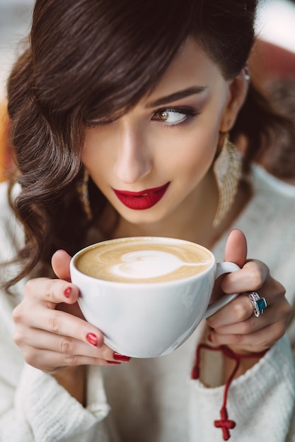 トレンディなカフェでコーヒーを飲む若い女の子 無料の写真