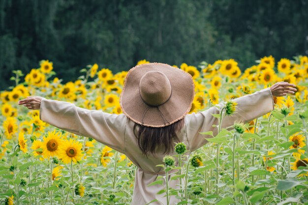 Premium Photo | Young girl in a hat on a field of sunflowers