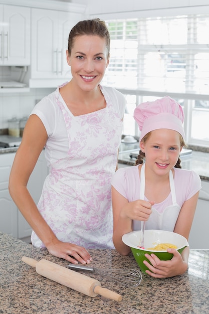 Premium Photo | Young girl helping mother prepare food in kitchen