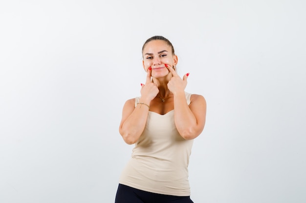 Free Photo | Young girl holding index fingers near mouth, forcing a ...