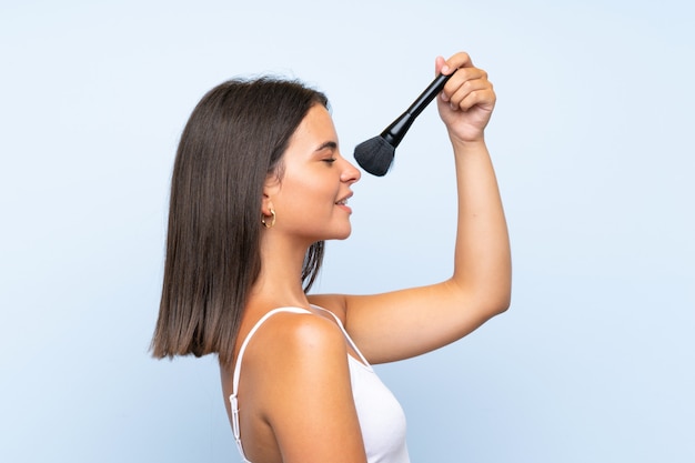Young Girl Holding Makeup Brush Over Isolated Wall Pr