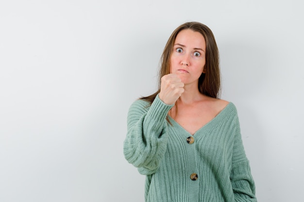 Free Photo | Young girl in knitwear, skirt clenching fist, curving lips ...