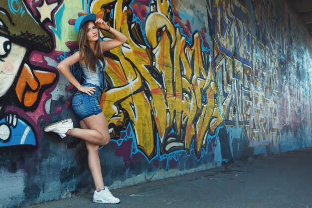 Premium Photo | Young girl posing against wall with graffiti