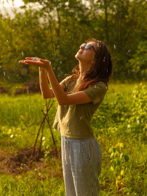 Premium Photo | Young girl that is enjoying the rain in a hot summer day