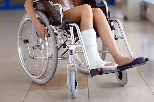 A young girl in a wheelchair is standing in the corridor of the hospital. Premium Photo