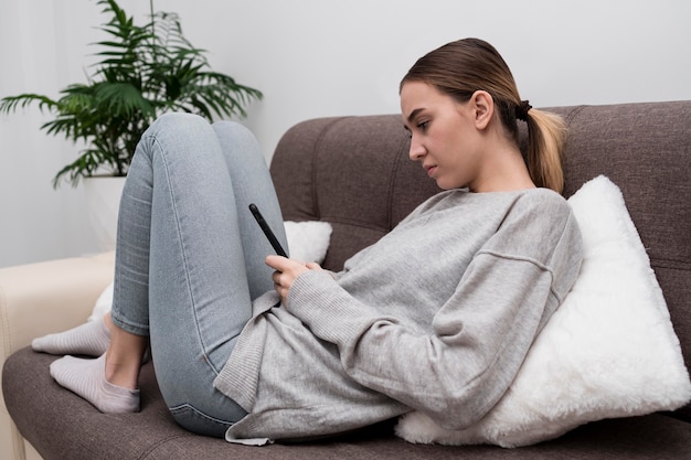 Free Photo | Young girl with phone on couch