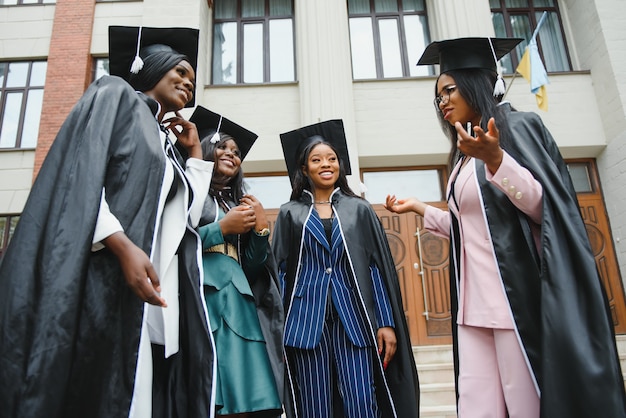 Premium Photo | Young graduates standing in front of university ...