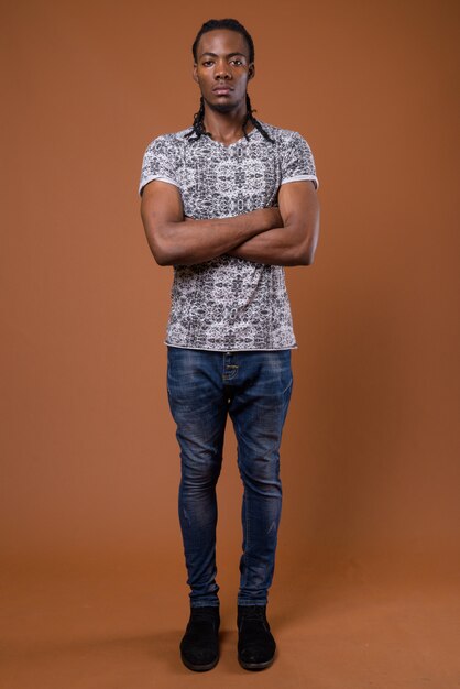 Young handsome african man against brown background | Premium Photo