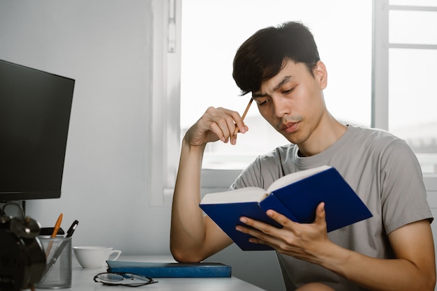 young handsome asian man reading book thinking gesture work desk free time from working home knowledge learning concept 34168 1740 - Persiapan Tes IELTS: 5 Hal yang Wajib Diketahui Sebelum Tes