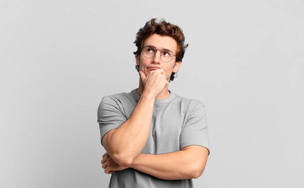 Premium Photo | Young handsome boy thinking, feeling doubtful and ...