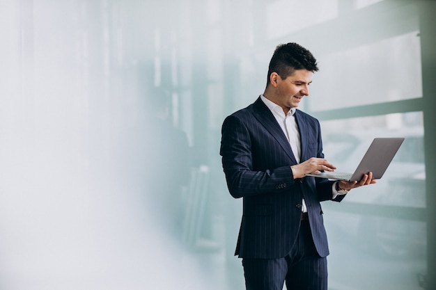 Young handsome business man with laptop in office Free Photo