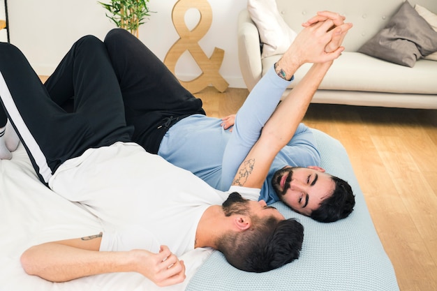 Free Photo Young Handsome Gay Couple Lying On Bed Holding Each Other S Hand