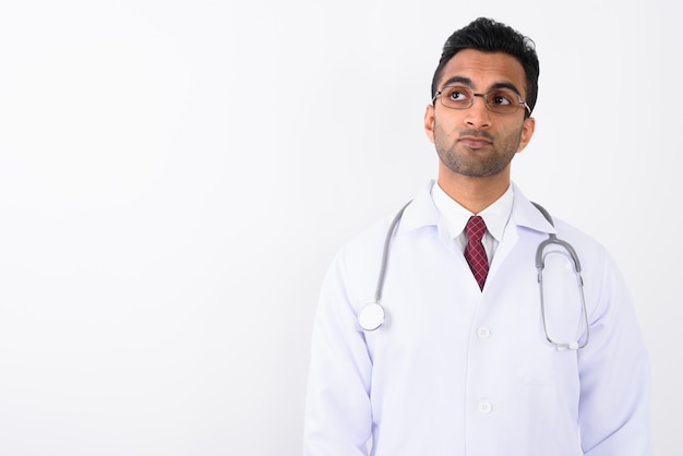 Premium Photo | Young handsome indian man doctor against white background