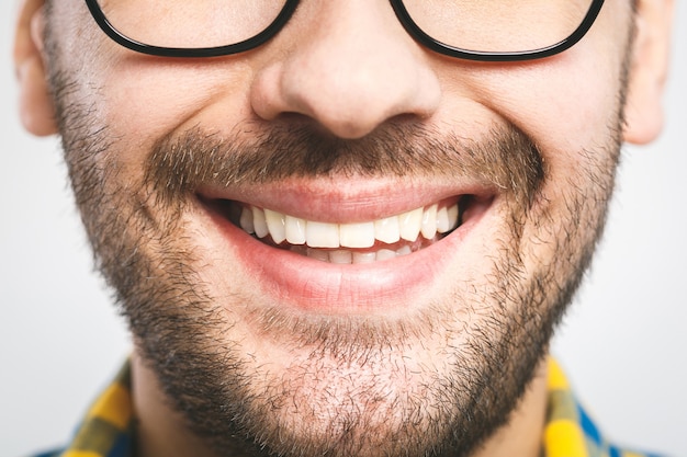 Closeup View Of Smiling Young Man In White Blank Tshirt Studio Portrait