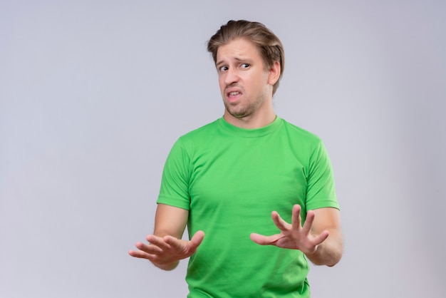 Free Photo Young Handsome Man Wearing Green Tshirt Holding His Hands