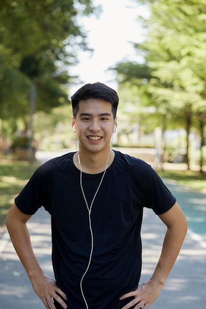 Premium Photo | Young handsome thai man exercising outdoors listening to  music in the park. copy space for text