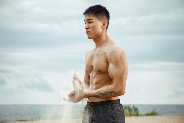 ビーチで運動をしている若い健康な男性アスリート 晴れた日の川沿いでのサイン男性モデル上半身裸のトレーニング空気 健康的なライフスタイル スポーツ フィットネス ボディービルの概念 無料の写真