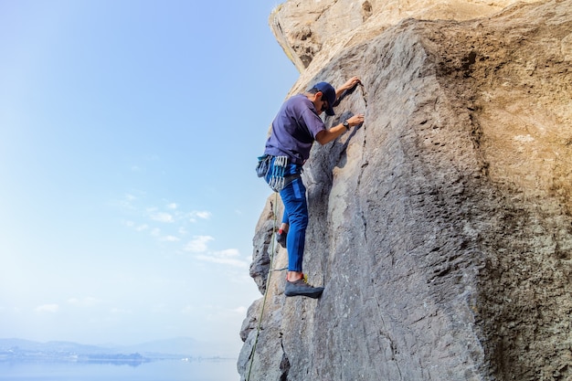 Young hispanic man with a rope engaged in the sports of rock climbing on the rock Free Photo