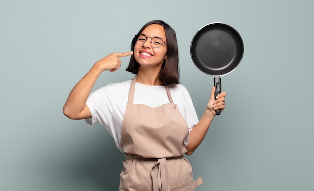 Young hispanic woman smiling confidently pointing to own broad smile, positive, relaxed, satisfied attitude Premium Photo