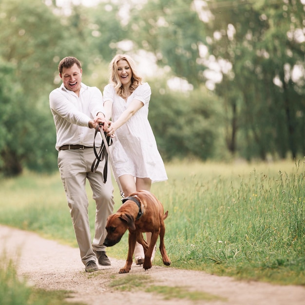 Premium Photo | Young husband and his wife have fun with their pet dog ...