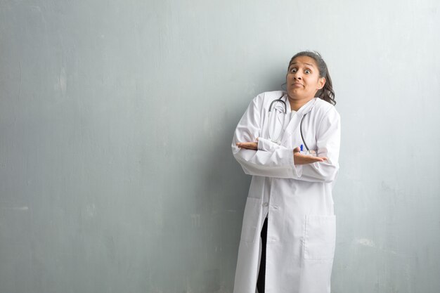 Premium Photo | Young indian doctor woman against a wall doubting and ...